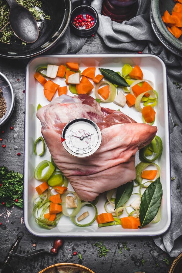 Porco assado que cozinha a preparação na tentativa do cozimento com vegetais e o temporizador da grade no fundo rústico da mesa d imagem de stock Porco assado que cozinha a preparação na tentativa do cozimento com vegetais e o temporizador da grade no fundo rústico da mesa d imagem de stock