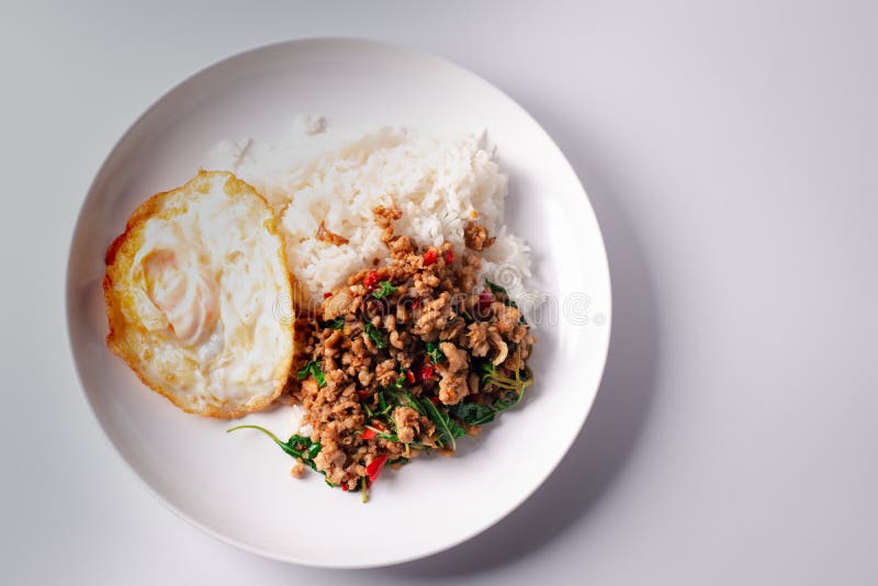 Pork Basil with Fried Egg in a White Plate on a White Background Stock