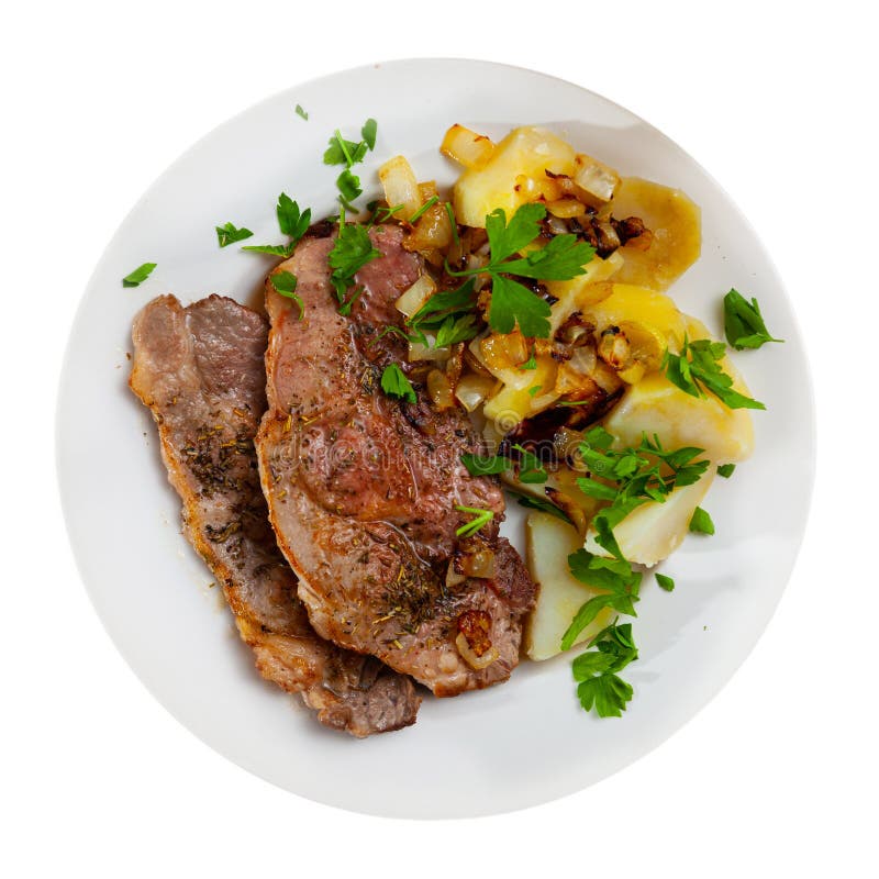 Pork chops with boiled potato, fried onion and parsley. Juicy pork chops with vegetable garnish of boiled potato, fried onion and chopped fresh parsley. Isolated