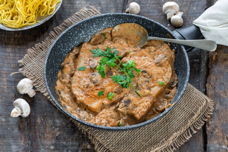 Pork chops in creamy cajun sauce with button mushrooms and egg noodles royalty free stock photos Pork chops in creamy cajun sauce with button mushrooms and egg noodles royalty free stock photos