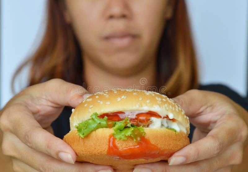 Pork hamburger dressing tomato sauce on woman hand royalty free stock photography