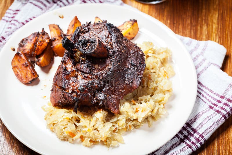 Pork Knuckle with Fried Sauerkraut and Baked Potatoes Stock Photo