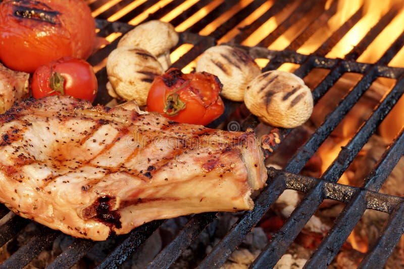 Pork Rib Steak, Tomato And Mushrooms On Hot BBQ Grill