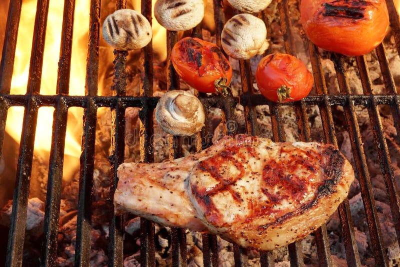 Pork Rib Steak, Tomato And Mushrooms On Hot BBQ Grill