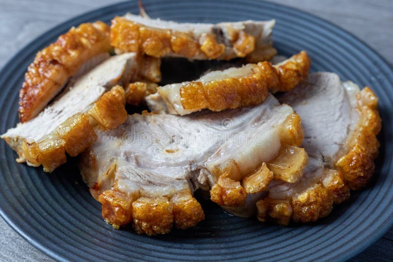 Pork Roast with Crackling on a Black Plate Ready To Eat Stock Photo