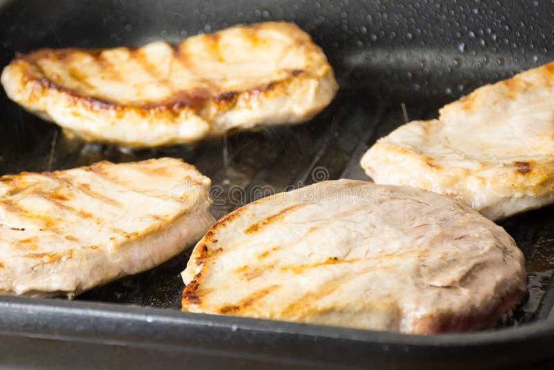 Pork steaks on frying pan stock image. Image of eating 72434061