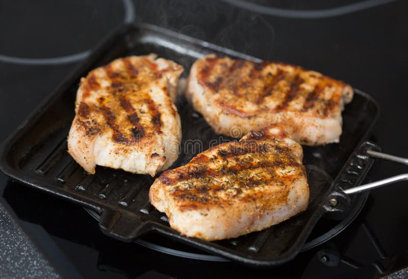 Pork steaks on a grill pan stock image. Image of grill 40786043