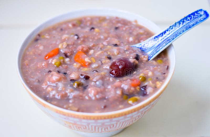 Porridge cinese sano del grano in una ciotola con la giuggiola & la bacca di Goji sulla cima immagine stock libera da diritti Porridge cinese sano del grano in una ciotola con la giuggiola & la bacca di Goji sulla cima immagine stock libera da diritti