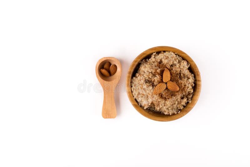 Porridge, Cinnamon and Almonds and in the Spoon on top in a wooden bowl and wooden spoon isolated on white background stock images Porridge, Cinnamon and Almonds and in the Spoon on top in a wooden bowl and wooden spoon isolated on white background stock images