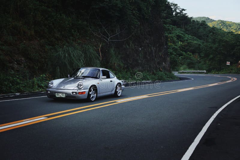 This particular Porsche 964 Carrera 2 is an air-cooled Porsche 911. Here it is driving through the twisty mountain pass of the Ternate-Nasugbu Highway on the northern part of Mt. Pico de Loro in the Philippines. This particular Porsche 964 Carrera 2 is an air-cooled Porsche 911. Here it is driving through the twisty mountain pass of the Ternate-Nasugbu Highway on the northern part of Mt. Pico de Loro in the Philippines.