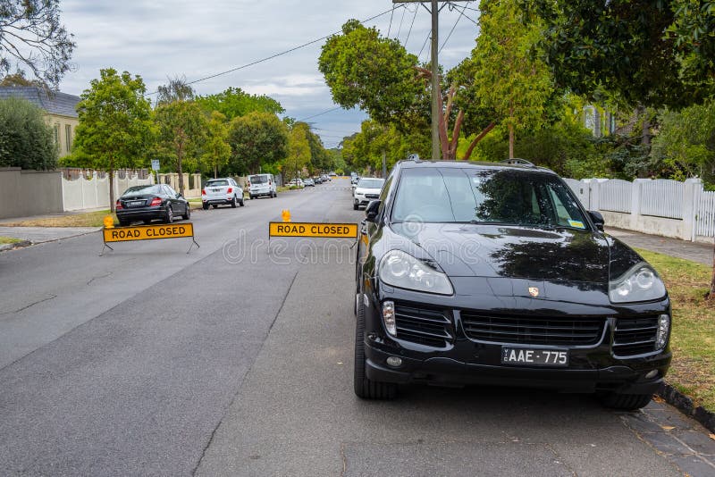 Porsche cayenne припаркованная перед дорогой закрыл знаки стоковая фотография