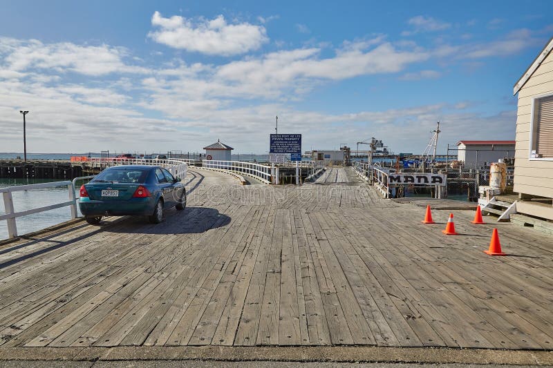 Bluff, New Zealand - March 16, 2016: Pier in the harbor of Bluff, docking place for the ferry connecting to Oban, Stewart Island, Rakiura. Bluff, New Zealand - March 16, 2016: Pier in the harbor of Bluff, docking place for the ferry connecting to Oban, Stewart Island, Rakiura