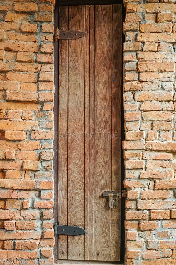 Porta alta sul muro di mattoni fotografia stock Porta alta sul muro di mattoni fotografia stock