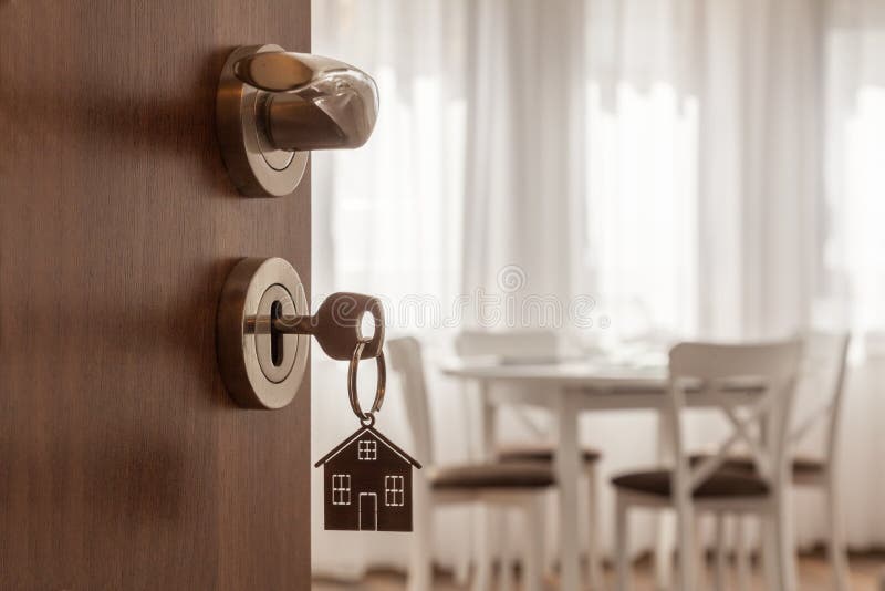 Porta aperta ad una nuova casa La maniglia di porta con la chiave e la casa ha modellato il keychain Ipoteca, investimento, bene