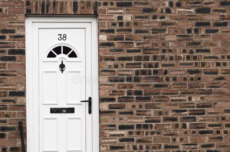 Porta da rua branca de uma casa de cidade inglesa do tijolo vermelho manchester