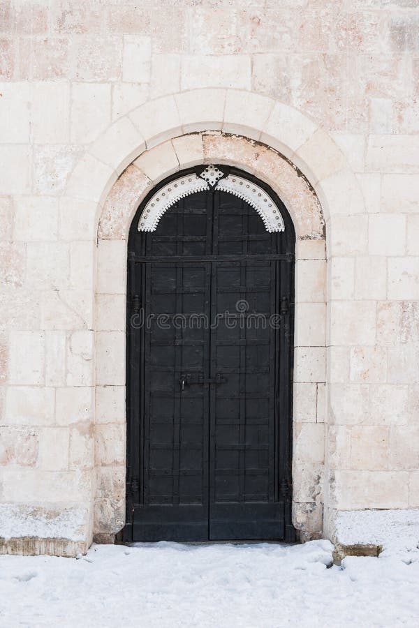 A porta da rua est? em uma parede de pedra antiga, a porta velha do ferro forjado do metal ? travada Fechamento fechado do metal fotografia de stock A porta da rua est? em uma parede de pedra antiga, a porta velha do ferro forjado do metal ? travada Fechamento fechado do metal fotografia de stock