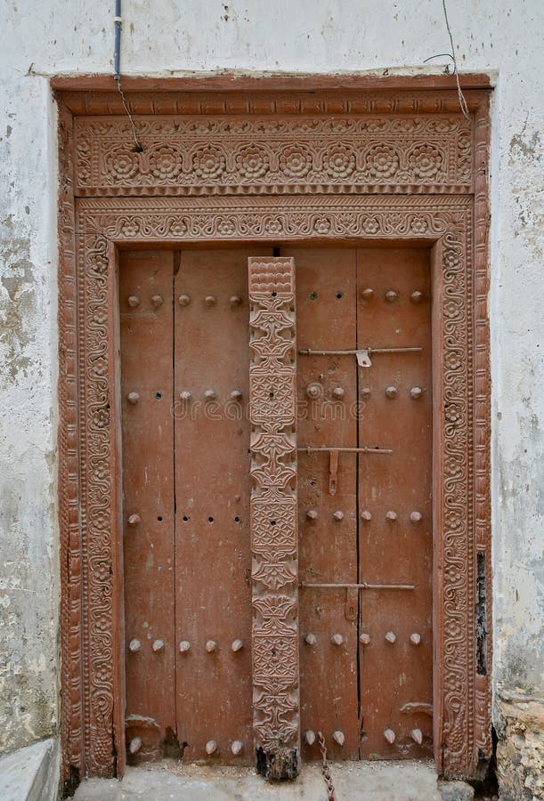 Old wooden door, with traditional carvings in the city of Stonetown, capital of the Tanzianian island of Zanzibar. Old wooden door, with traditional carvings in the city of Stonetown, capital of the Tanzianian island of Zanzibar