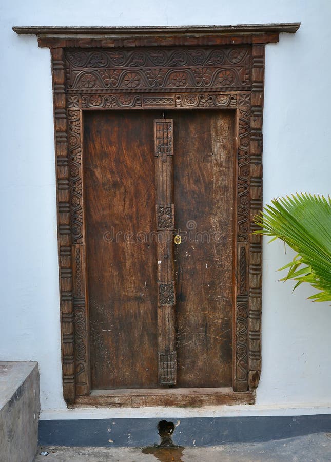 Old wooden door, with traditional carvings in the city of Stonetown, capital of the Tanzianian island of Zanzibar. Old wooden door, with traditional carvings in the city of Stonetown, capital of the Tanzianian island of Zanzibar