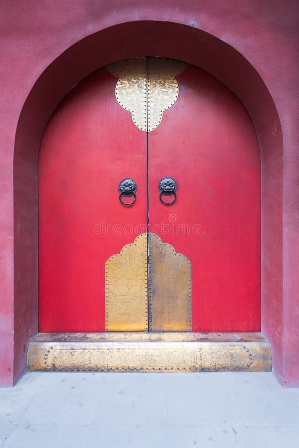 Porta rossa tradizionale cinese con gli ornamenti dorati immagine stock libera da diritti Porta rossa tradizionale cinese con gli ornamenti dorati immagine stock libera da diritti