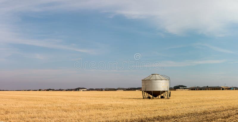 Portable grain silos sitting in a recently harvested field of crops on a farm in rural Victoria, Australia