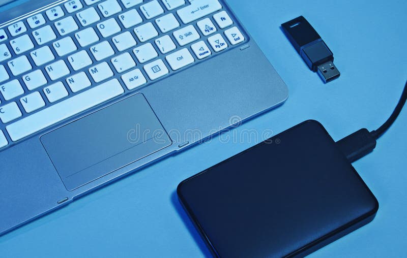 A Portable Hard Drive a Laptop and a USB Flash Drive Stock Photo