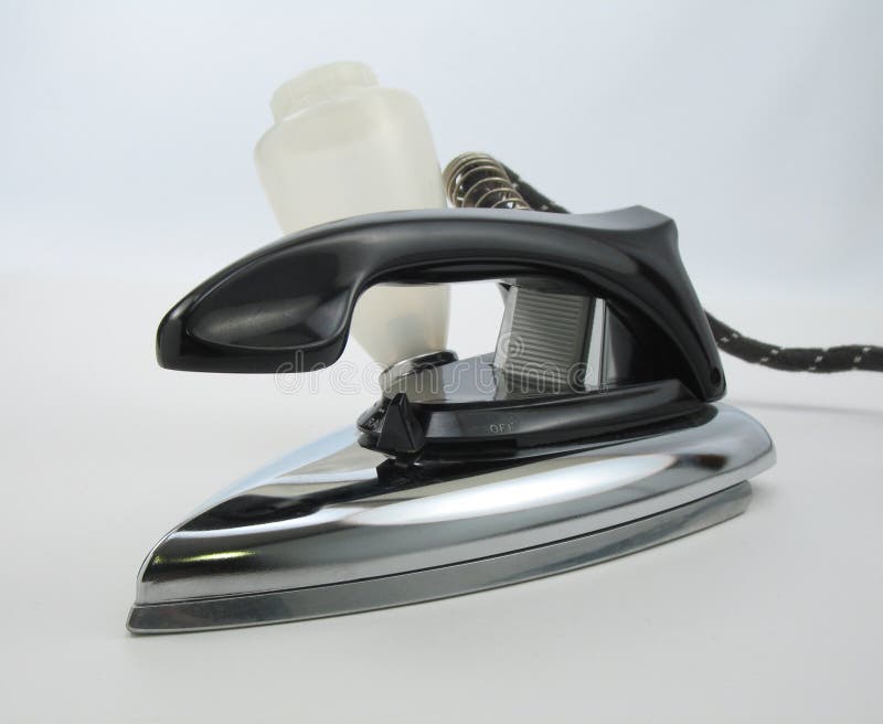 An old portable electric steam iron on a blue-white background. Warm steam stock images, royalty-free photos and pictures