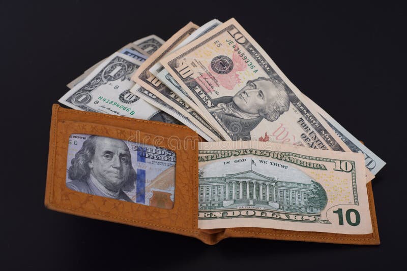 Yellow leather wallet with money lying on a dark background. Yellow leather wallet with money lying on a dark background