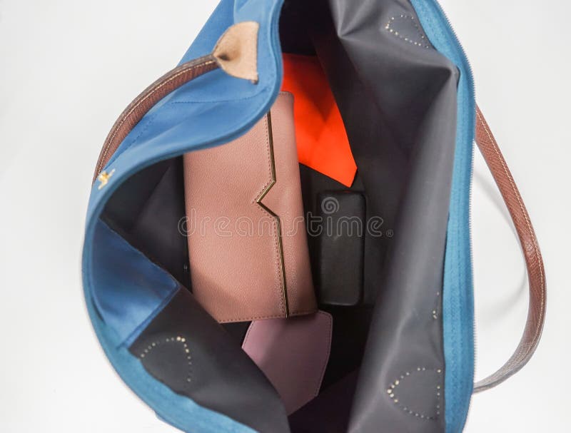 Portafoglio ed accessori isolati della donna dentro la borsa d'avanguardia verde fotografie stock Portafoglio ed accessori isolati della donna dentro la borsa d'avanguardia verde fotografie stock