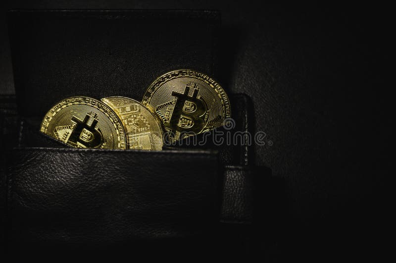 Portafoglio in pieno delle monete shinning dei bitcoins dorati di cryptocurrency su fondo nero e scuro Pila di monete cripto cons fotografia stock libera da diritti Portafoglio in pieno delle monete shinning dei bitcoins dorati di cryptocurrency su fondo nero e scuro Pila di monete cripto cons fotografia stock libera da diritti