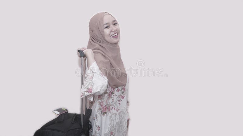 Portait av den b?rande huvudhalsduken eller hijab f?r asiatisk muslim kvinna som rymmer resv?skabagage royaltyfri foto Portait av den b?rande huvudhalsduken eller hijab f?r asiatisk muslim kvinna som rymmer resv?skabagage royaltyfri foto