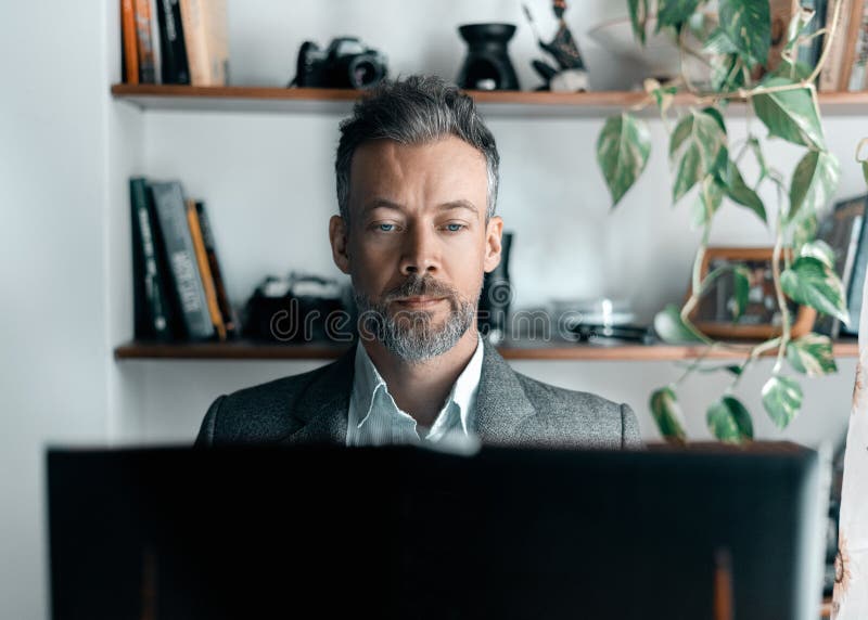Portait of serious looking business man working on computer stock image
