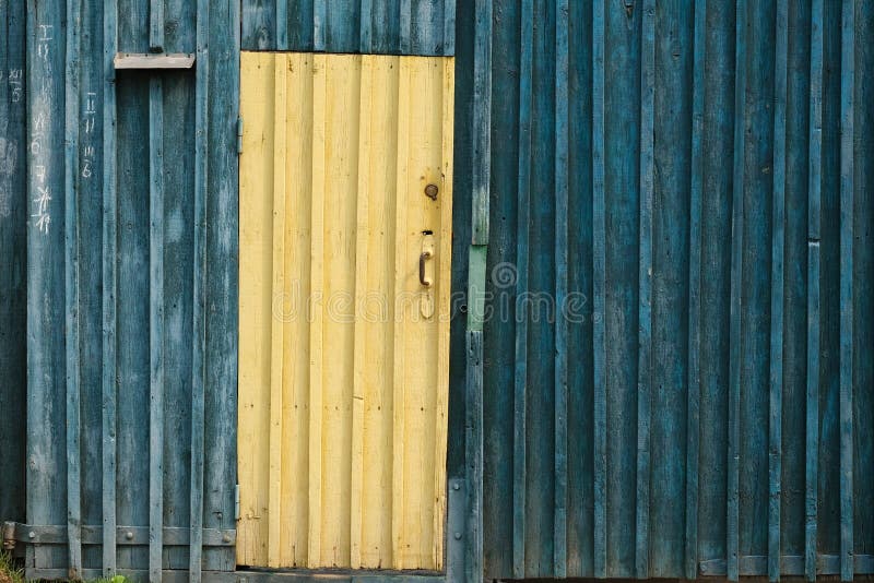 Porte di legno giallo su uno sfondo di pannelli blu scuro immagine stock Porte di legno giallo su uno sfondo di pannelli blu scuro immagine stock