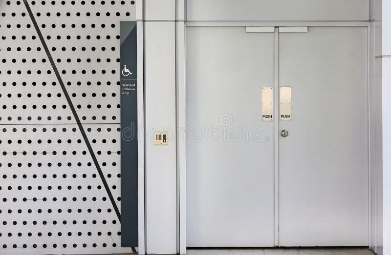 Porte en métal pour l'entrée handicapée seulement avec la poussée des textes sur la porte photos libres de droits Porte en métal pour l'entrée handicapée seulement avec la poussée des textes sur la porte photos libres de droits