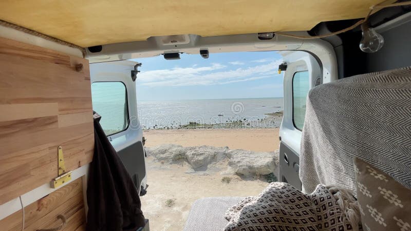 Porte ouverte vue statique de la fourgonnette auto-convertie en face de l'océan atlantique en france. banque de vidéos