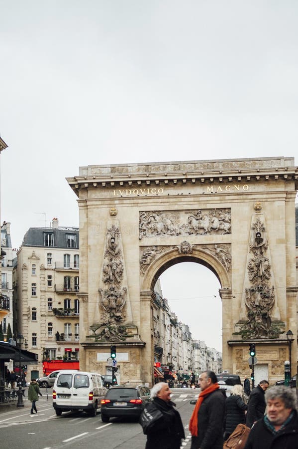 PARIS, FRANCE - JAN 23, 2013: Porte Saint-Denis triumphal arch with the entablature bronze inscription LUDOVICO MAGNO, To Louis the Great. PARIS, FRANCE - JAN 23, 2013: Porte Saint-Denis triumphal arch with the entablature bronze inscription LUDOVICO MAGNO, To Louis the Great