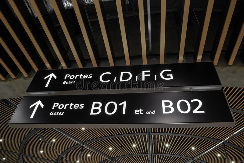 Portes de las puertas y muestras de las flechas dentro del terminal 1 en el santo Exupery International Airport, Francia de Lyon imágenes de archivo libres de regalías Portes de las puertas y muestras de las flechas dentro del terminal 1 en el santo Exupery International Airport, Francia de Lyon imágenes de archivo libres de regalías