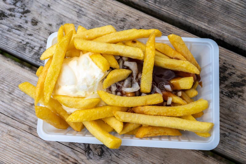 Portion Of French Fried Potato Chips With Curry And Mayonnaise Sauce portion-of-french-fried-potato-chips-with-curry-and-mayonnaise-sauce