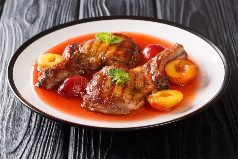Portion of Grilled Pork Chop with Plums and Fruit Sauce Closeup in a