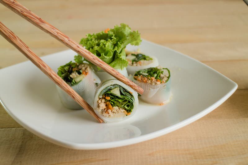 Portion off fresh spring rolls,vegetable and pork on white plate wood table. stock photo Portion off fresh spring rolls,vegetable and pork on white plate wood table. stock photo