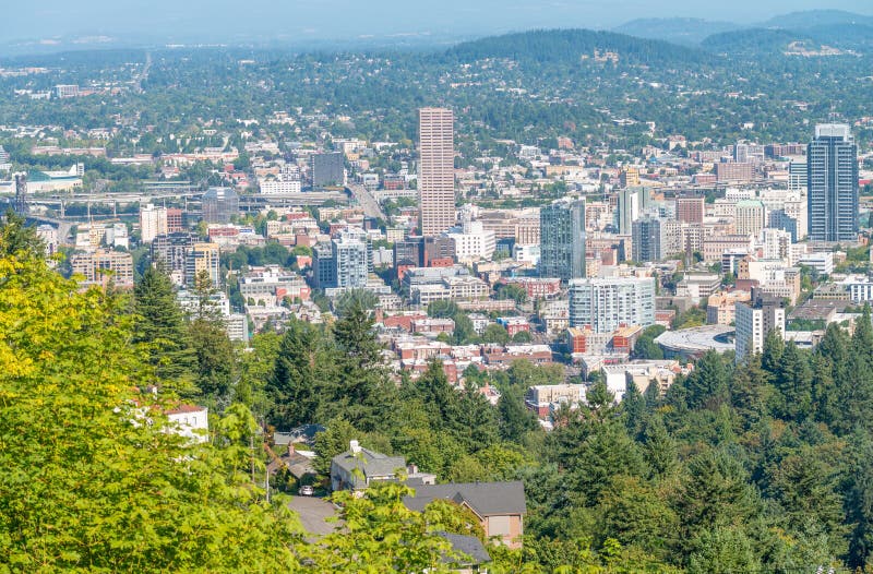 PORTLAND, OR - AUGUST 19, 2017: City aerial skyline from the hill. The city attracts 5 million people annually. PORTLAND, OR - AUGUST 19, 2017: City aerial skyline from the hill. The city attracts 5 million people annually.