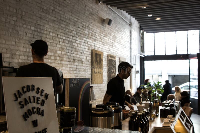 Portland, Oregon / USA - April 4, 2018: Visitors to downtown Portland gather inside a Stumptown Coffee location while baristas expertly prepare espresso drinks. Portland, Oregon / USA - April 4, 2018: Visitors to downtown Portland gather inside a Stumptown Coffee location while baristas expertly prepare espresso drinks.