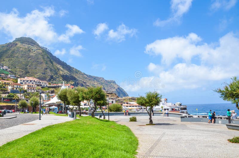 Porto Moniz, Madeira, Portugal - 13 de setembro de 2019: Promenade com grama e árvores verdes no resort de férias de verão em Por imagens de stock Porto Moniz, Madeira, Portugal - 13 de setembro de 2019: Promenade com grama e árvores verdes no resort de férias de verão em Por imagens de stock