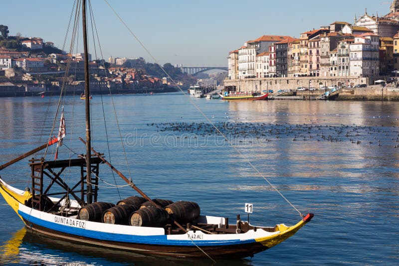 PORTO, PORTUGAL - JANEIRO 18,2018: Barcos que levam tambores do embarcadouro visto vinho de Porto no banco de rio Opinião do pano fotos de stock PORTO, PORTUGAL - JANEIRO 18,2018: Barcos que levam tambores do embarcadouro visto vinho de Porto no banco de rio Opinião do pano fotos de stock