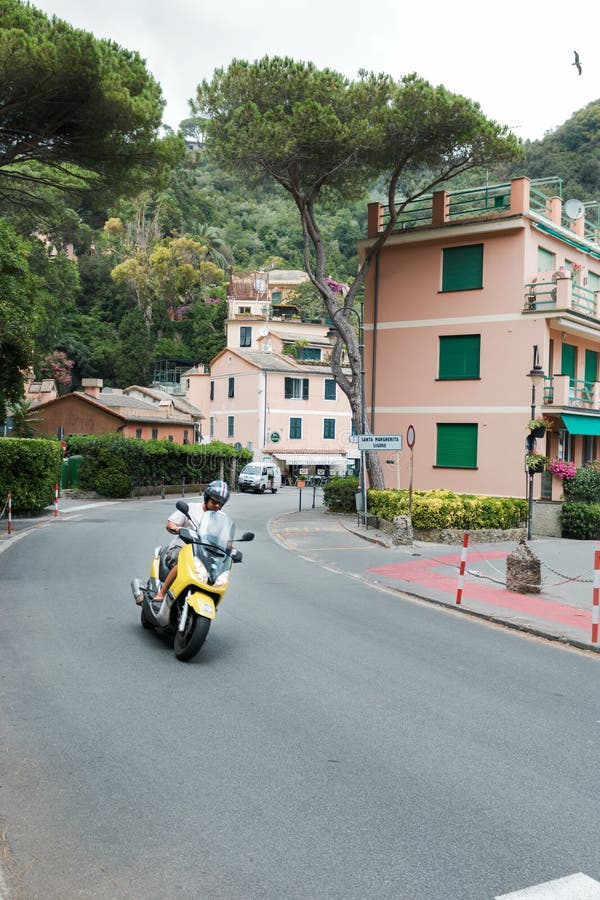 Portofino, Italië, 19 Juli, 2017: Mens op autoped die uit hoek komen royalty-vrije stock afbeelding Portofino, Italië, 19 Juli, 2017: Mens op autoped die uit hoek komen royalty-vrije stock afbeelding