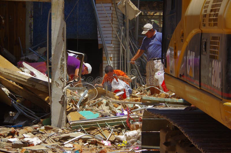 Portoviejo, Ecuador - April, 18, 2016: Building showing the aftereffect of 7.8 earthquake that destroyed the city center, with people looking for their belongings in the rubble.