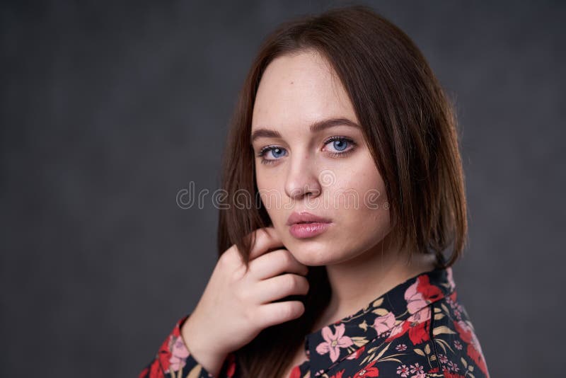 Portr?t einer Frau in einem farbigen Kleid auf grauem Hintergrund lizenzfreies stockfoto Portr?t einer Frau in einem farbigen Kleid auf grauem Hintergrund lizenzfreies stockfoto