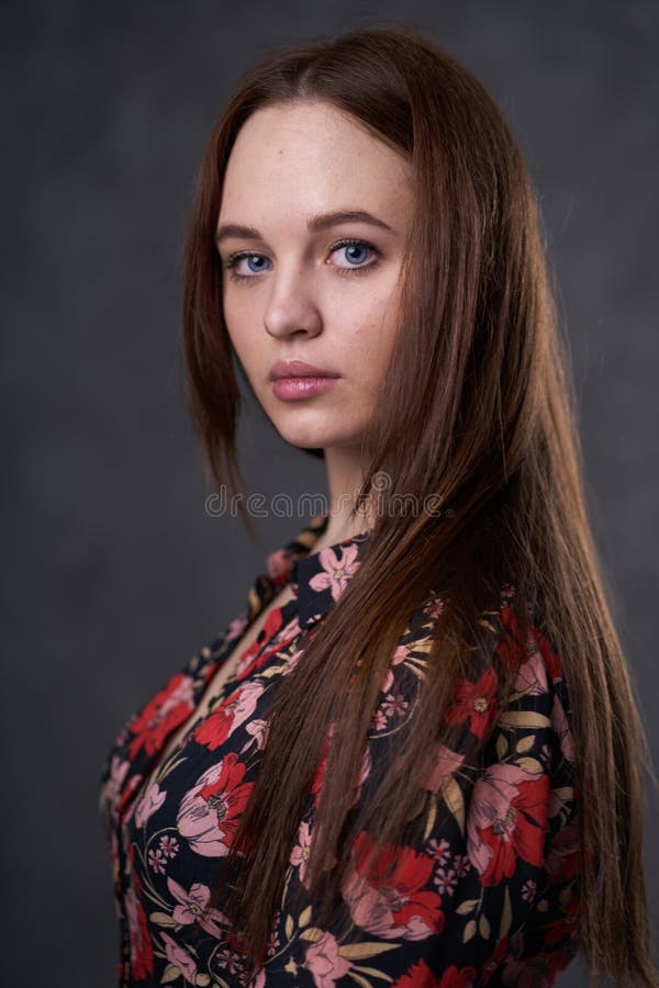 Portr?t einer Frau in einem farbigen Kleid auf grauem Hintergrund lizenzfreies stockbild Portr?t einer Frau in einem farbigen Kleid auf grauem Hintergrund lizenzfreies stockbild