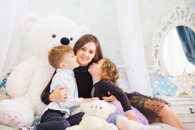 Portr? t einer gl? cklichen Mutter und ihrer zwei kleinen Kinder - Junge und M? dchen Gl? ckliches Familien-Portrait Kleinkinder, die stockfotografie
