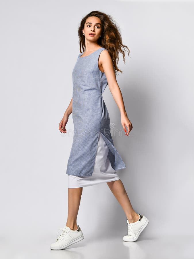Portr?t einer jungen brunette Frau in einem Blaulichtkleid, das auf einem hellen Hintergrund, Sommermode, bereitend f?r ein Datum lizenzfreies stockfoto Portr?t einer jungen brunette Frau in einem Blaulichtkleid, das auf einem hellen Hintergrund, Sommermode, bereitend f?r ein Datum lizenzfreies stockfoto