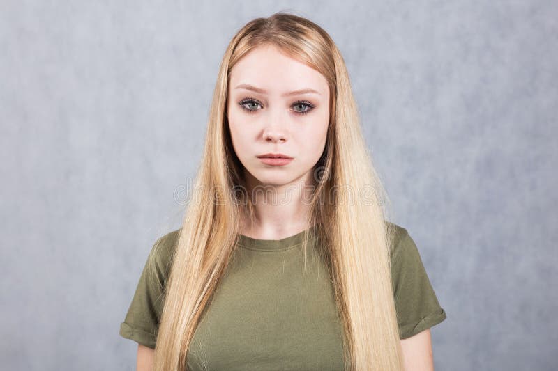 Portr?t einer jungen sch?nen traurigen Frau auf einem grauen Hintergrund lizenzfreie stockbilder Portr?t einer jungen sch?nen traurigen Frau auf einem grauen Hintergrund lizenzfreie stockbilder